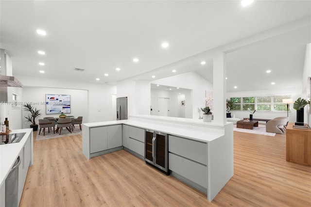 kitchen with wine cooler, gray cabinetry, kitchen peninsula, and stainless steel refrigerator with ice dispenser