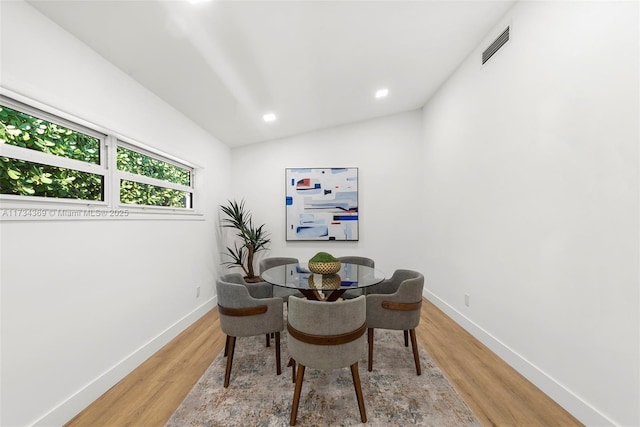 dining area with lofted ceiling and hardwood / wood-style flooring