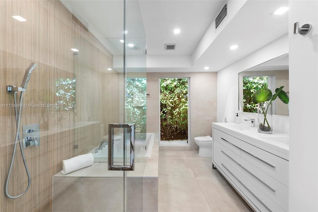 full bathroom featuring tile patterned floors, toilet, vanity, independent shower and bath, and a wealth of natural light