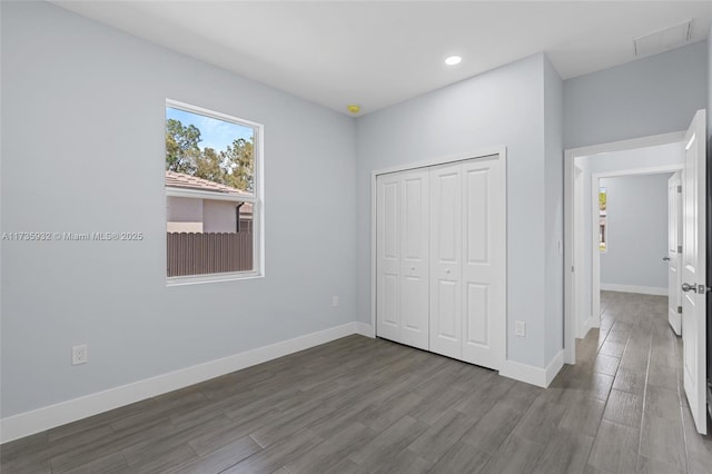 unfurnished bedroom featuring hardwood / wood-style flooring and a closet