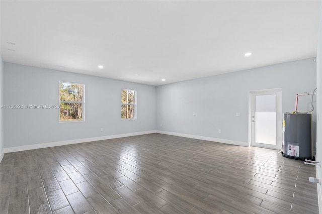 spare room featuring dark hardwood / wood-style flooring and gas water heater