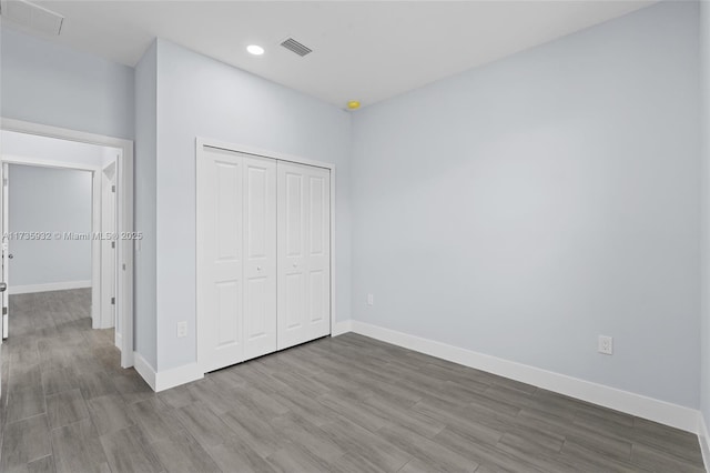 unfurnished bedroom featuring hardwood / wood-style floors and a closet