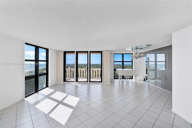 spare room featuring light tile patterned floors, a notable chandelier, and a wall of windows