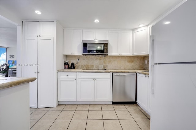 kitchen with light tile patterned flooring, tasteful backsplash, white cabinetry, stainless steel appliances, and light stone countertops