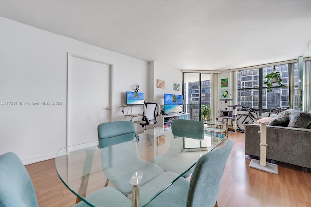 dining space featuring hardwood / wood-style floors and a wall of windows