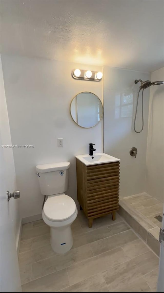 bathroom with vanity, a shower, and toilet