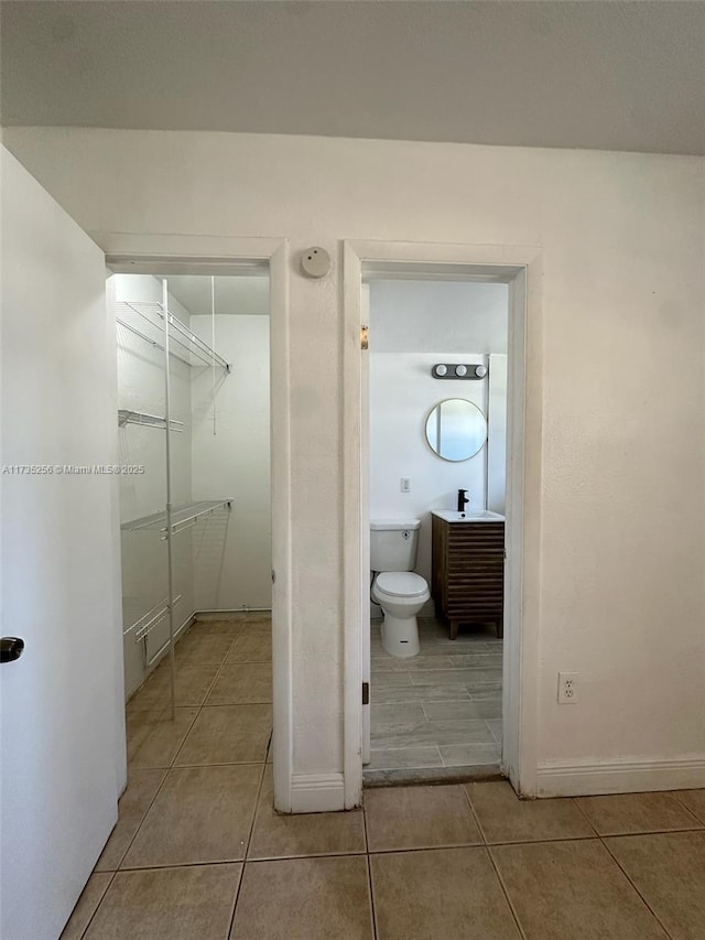 bathroom featuring sink, tile patterned floors, and toilet