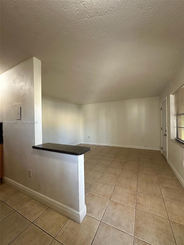 unfurnished room with light tile patterned floors and a textured ceiling