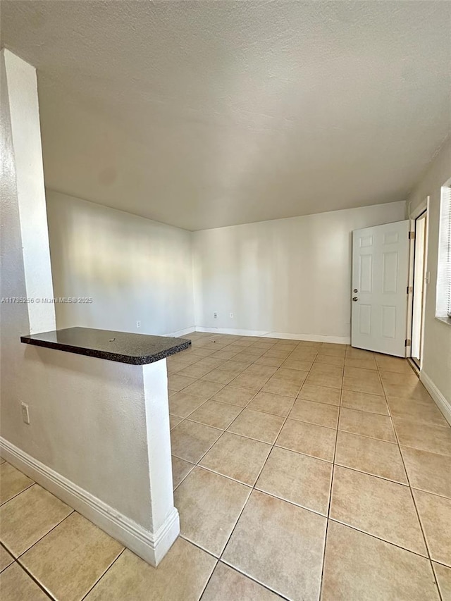 spare room with light tile patterned floors and a textured ceiling