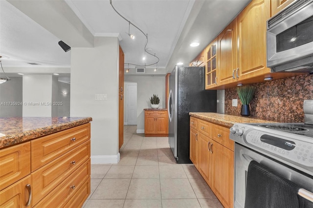 kitchen with stainless steel appliances, light stone countertops, light tile patterned floors, and backsplash