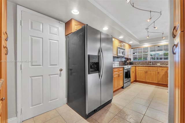 kitchen with light tile patterned floors, sink, backsplash, stainless steel appliances, and stone countertops