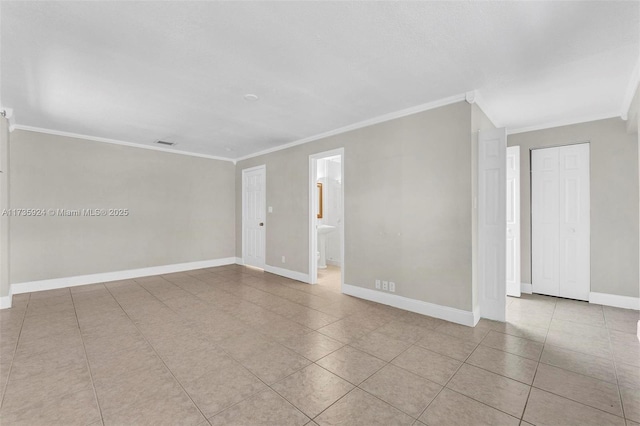 tiled empty room featuring crown molding