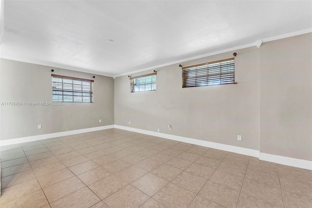 tiled empty room featuring crown molding