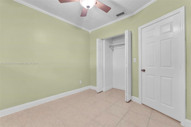 unfurnished bedroom featuring crown molding, light tile patterned flooring, ceiling fan, and a closet