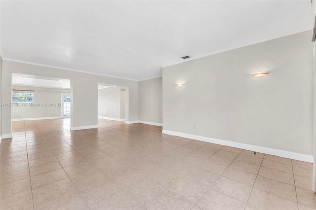 unfurnished room with light tile patterned floors and ornamental molding