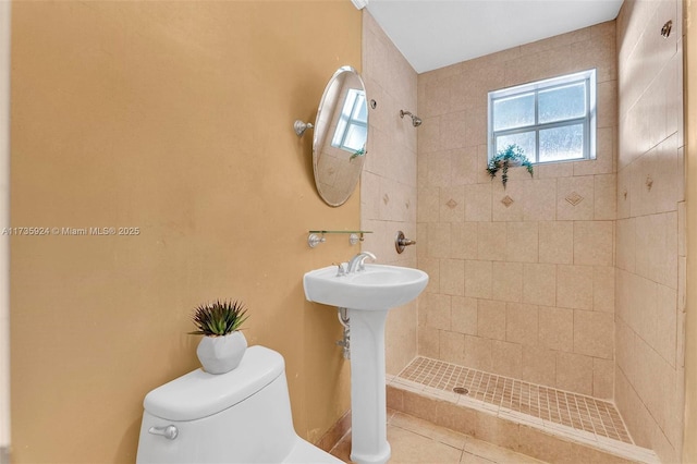 bathroom featuring tiled shower and toilet