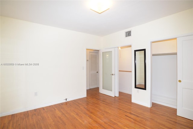 unfurnished bedroom featuring light hardwood / wood-style floors and french doors