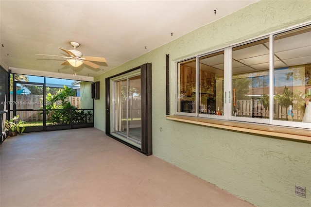 unfurnished sunroom featuring ceiling fan