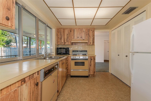 kitchen with sink, tasteful backsplash, range, dishwashing machine, and white fridge