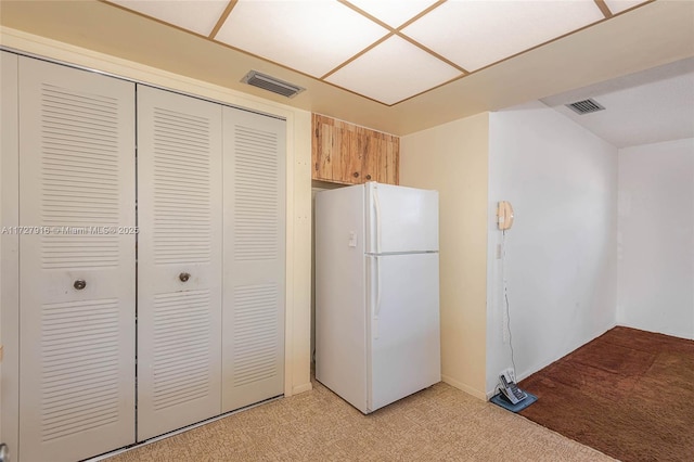 kitchen with white refrigerator and light colored carpet