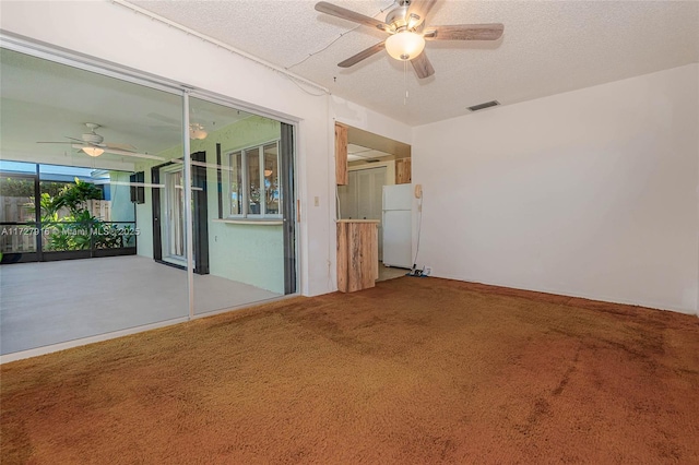 spare room featuring ceiling fan, carpet flooring, and a textured ceiling