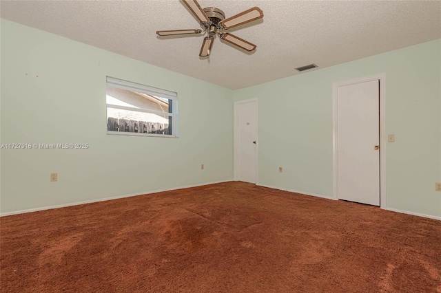 carpeted spare room featuring ceiling fan and a textured ceiling