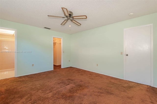 carpeted spare room featuring ceiling fan and a textured ceiling