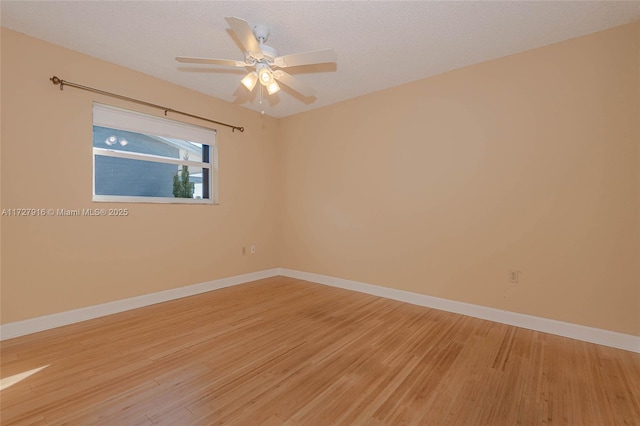 empty room featuring ceiling fan, hardwood / wood-style flooring, and a textured ceiling