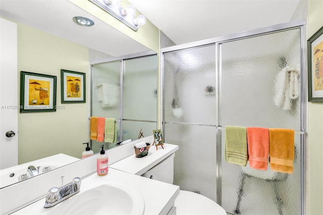 bathroom featuring vanity, toilet, and a shower with shower door