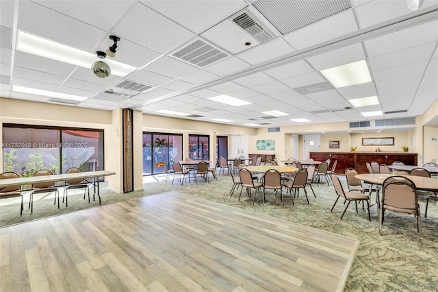 dining area featuring hardwood / wood-style floors and a paneled ceiling