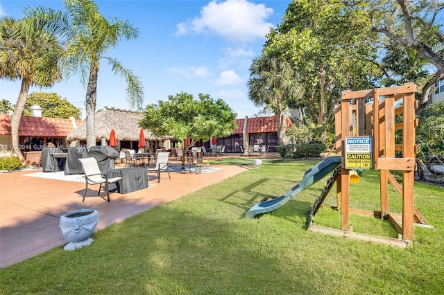 view of jungle gym featuring a yard and a patio area