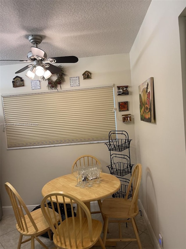 tiled dining space featuring ceiling fan and a textured ceiling