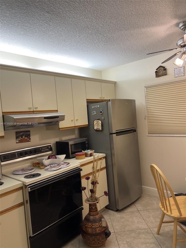 kitchen featuring appliances with stainless steel finishes, light tile patterned floors, ceiling fan, cream cabinets, and a textured ceiling