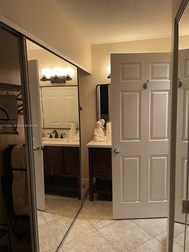 bathroom featuring vanity, tile patterned floors, and a textured ceiling