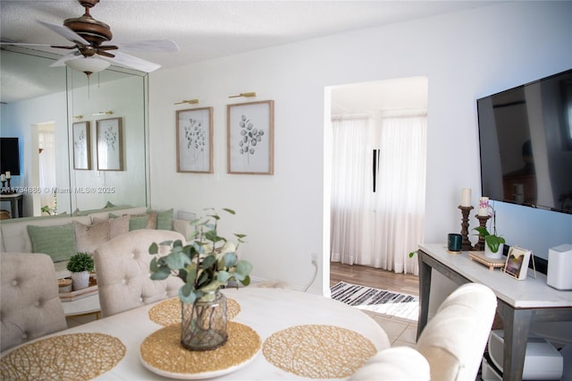 living room with ceiling fan and a textured ceiling