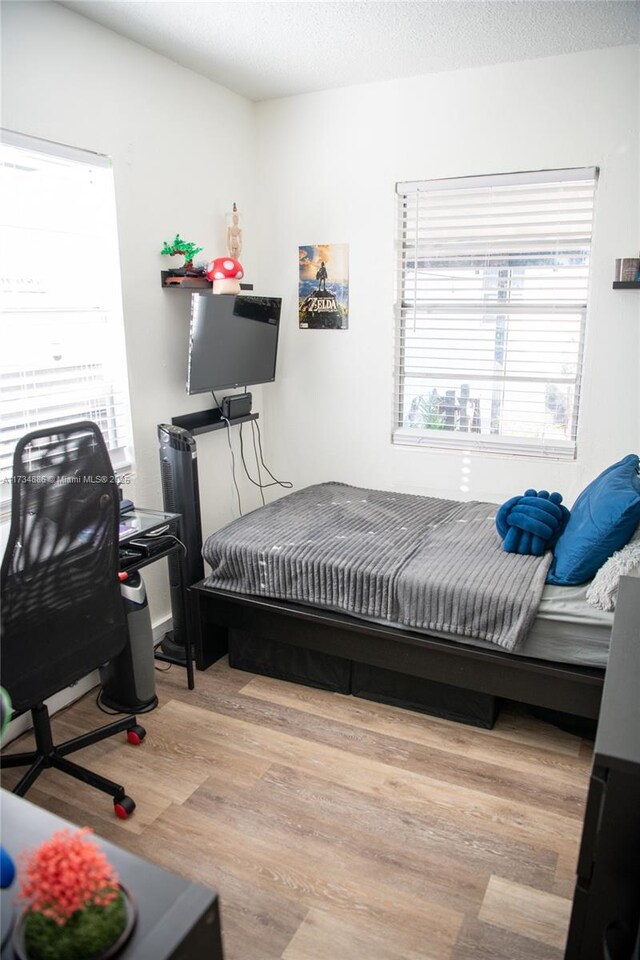 bedroom featuring a textured ceiling and light hardwood / wood-style flooring