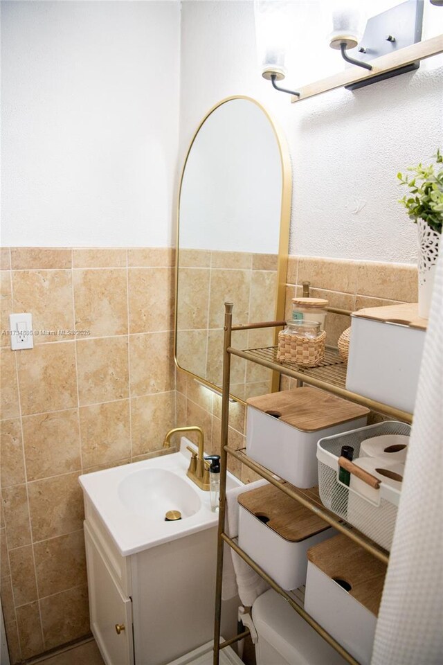 bathroom with vanity and tile walls