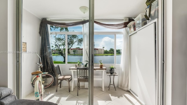 entryway featuring a water view and light tile patterned flooring