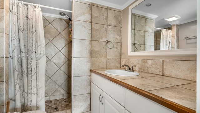 bathroom featuring vanity, tasteful backsplash, ornamental molding, and walk in shower