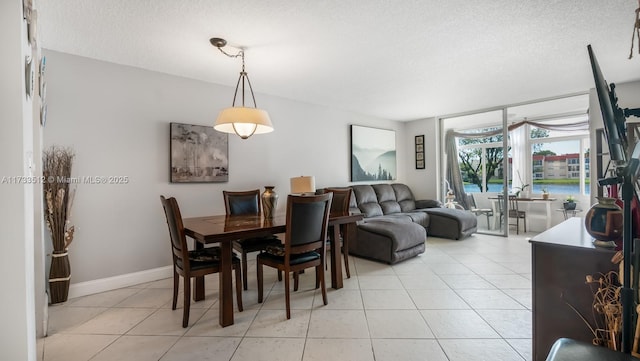 dining area with a textured ceiling and light tile patterned floors