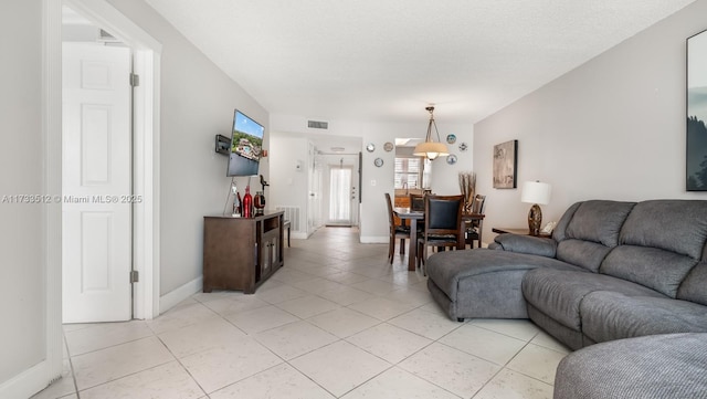 living room featuring a textured ceiling and light tile patterned floors