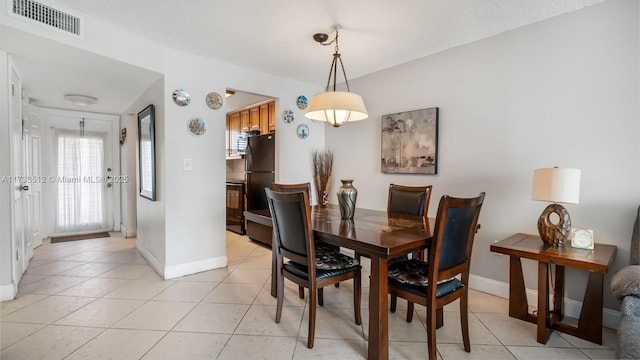 tiled dining space featuring a textured ceiling