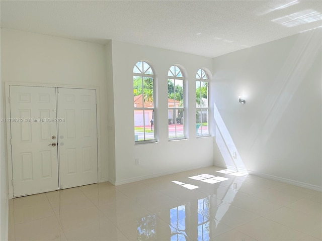 tiled entryway featuring a textured ceiling