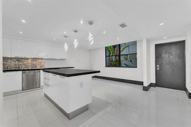 kitchen featuring white cabinetry, backsplash, hanging light fixtures, a center island, and stainless steel dishwasher