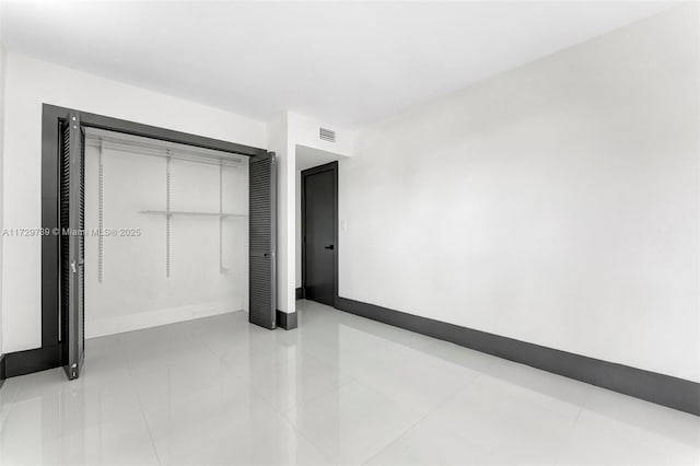 unfurnished bedroom featuring light tile patterned floors and a closet