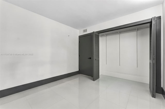 unfurnished bedroom with a closet and light tile patterned flooring