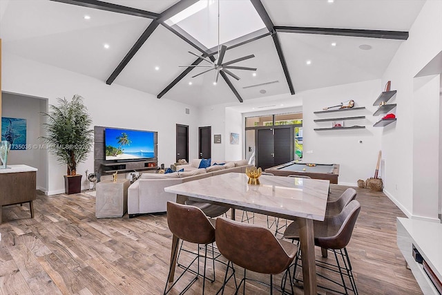 dining room featuring high vaulted ceiling, light hardwood / wood-style floors, and beamed ceiling