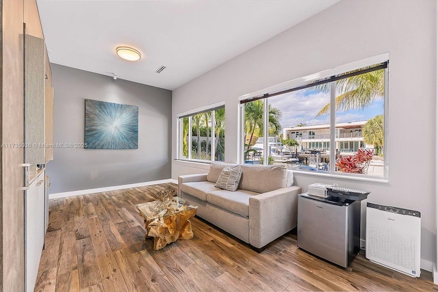 sitting room with light hardwood / wood-style flooring and radiator heating unit