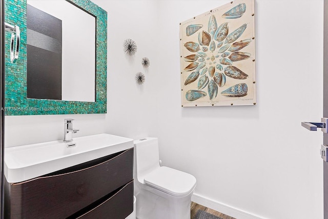 bathroom featuring hardwood / wood-style flooring, vanity, and toilet