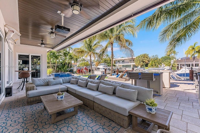 view of patio / terrace with an outdoor living space, exterior bar, and ceiling fan